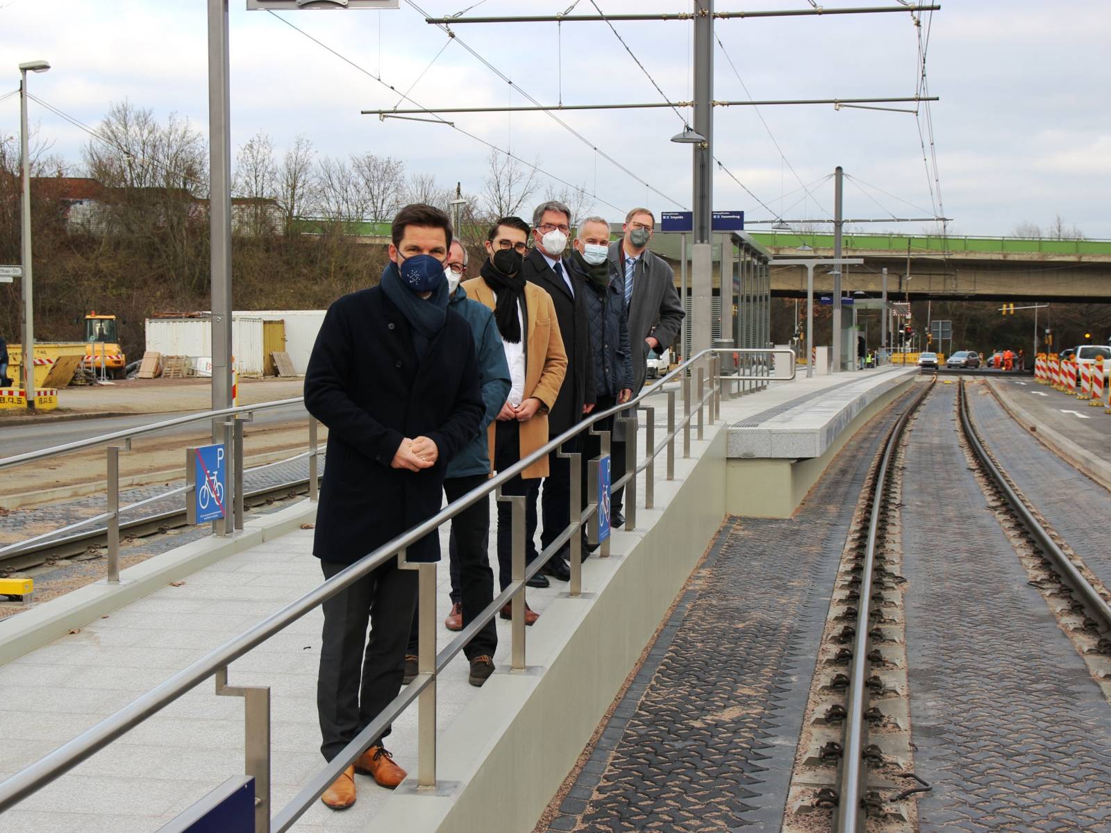 Sechs Personen auf dem barrierefreien Aufgang zu einem neuen Hochbahnsteig im Verkehrsnetz Hannovers.